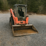 Kubota SVL75 compact track loader parked on gravel in New Brunswick, ready for landscaping and construction projects.