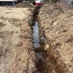 Freshly graded and leveled soil ready for seeding at a residential property in New Brunswick